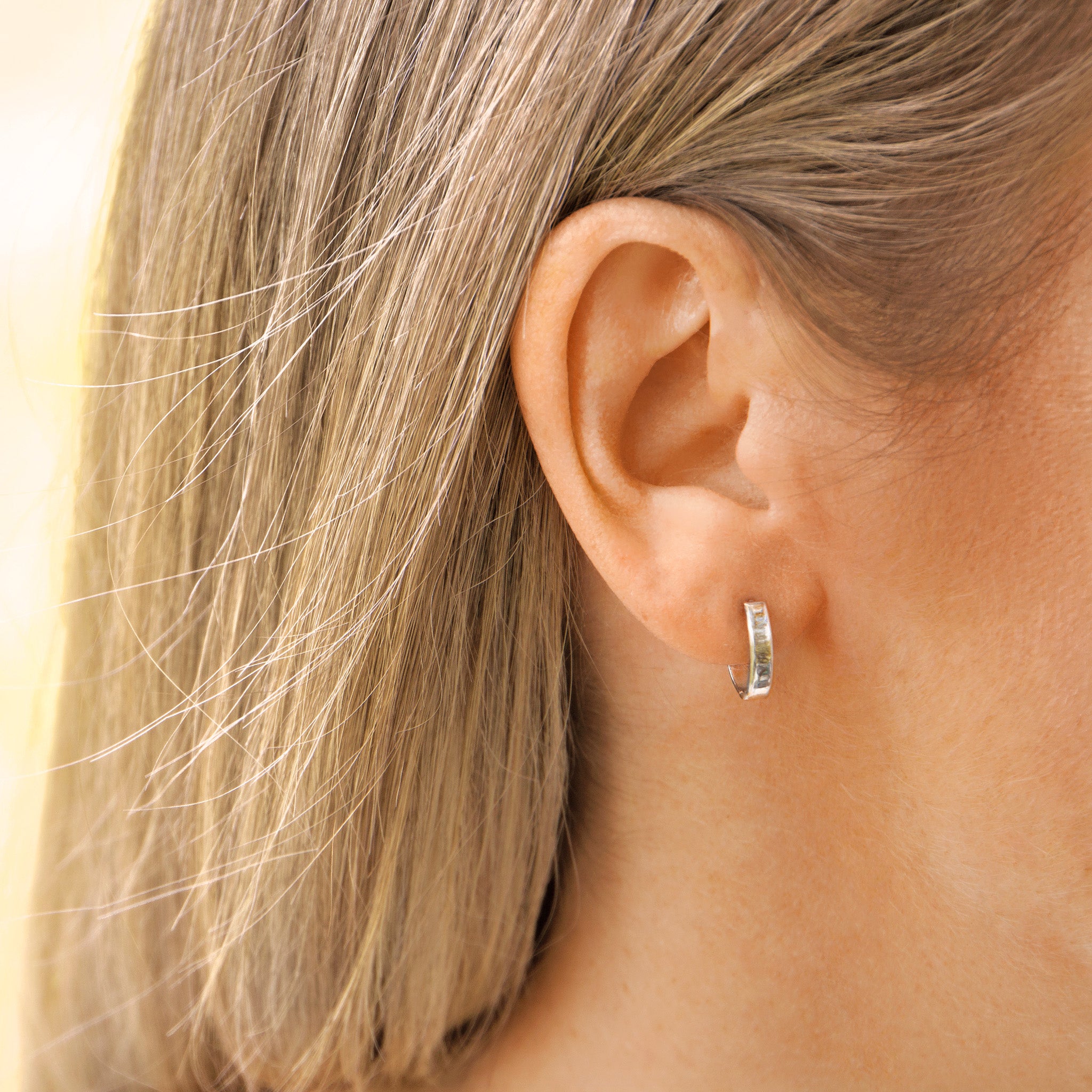 Solid White Gold huggie hoop earrings on ear- AïANA Australia