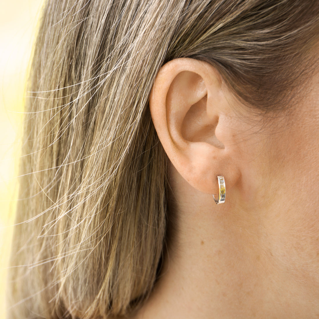 Gold hug earrings on ear- AïANA