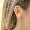Diamond stud and hug earring stack on ear - AïANA