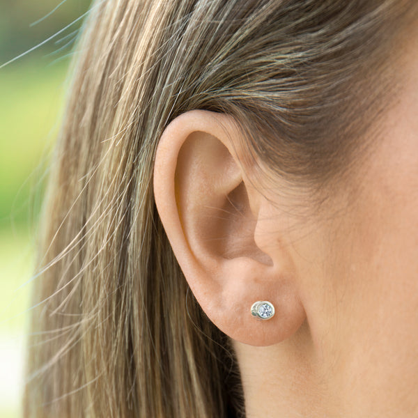 Bezel set diamond earring on ear - AïANA